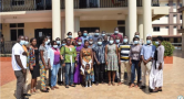 group of people pose for camera in front of building